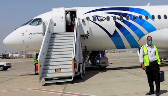 An employee of Luxors International Airport, wearing a protective face mask, walks next to an EgyptAir plane in Luxor, Egypt April 9, 2021. — Reuters