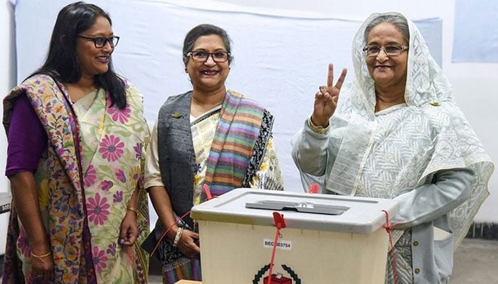 Sheikh Hasina (right) flashes the victory symbol after casting her vote, as her daughter Saima Wazed (left) and sister Sheikh Rehana (centre) stand next to her at a polling station in Dhaka. — AFP/File