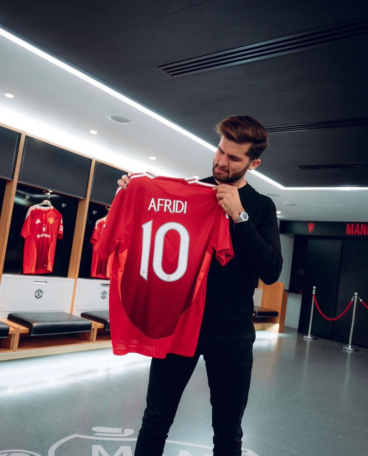 Pakistans cricket star Shaheen Shah Afridi poses with a jersey of Manchester United.  — photo provided by reporters