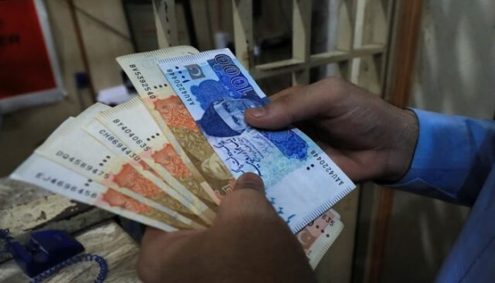 A man counts Pakistani rupee notes at a currency exchange shop in Peshawar on September 12, 2023. —Reuters