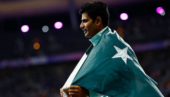 Arshad Nadeem poses with the national flag after winning the gold medal in the Mens Javelin Throw final event in Paris Olympics 2024 at Stade de France, Saint-Denis, France on August 08, 2024. — Reuters