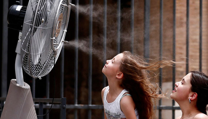 People stand in front of a cooler installed around the Colosseum amid a heatwave in Rome, Italy, June 21. — Reuters