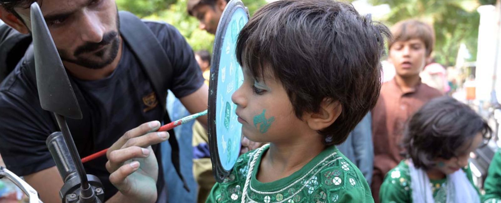 A child getting face painted in the colours of the flag of Pakistan at the occasion of the celebrations of the 77th Independence Day of the country on August 14, 2024 in Sargodha, Punjab, Pakistan. — APP