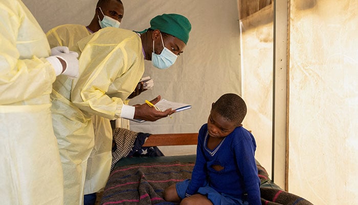 Dr Tresor Wakilongo, verifies the evolution of skin lesions on the ear of Innocent, suffering from Mpox at the treatment centre in Munigi, following Mpox cases in Nyiragongo territory near Goma, North Kivu province, Democratic Republic of the Congo July 19, 2024. — Reuters