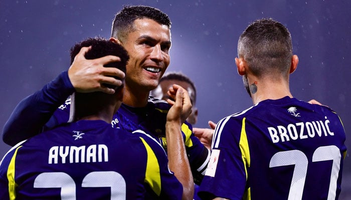 Al Nassrs striker Cristiano Ronaldo (centre) hugs his teammates after defeating Al Taawoun in the Saudi Super Cup 2024 semi-final on August 14, 2024. — Instagram/@cristiano