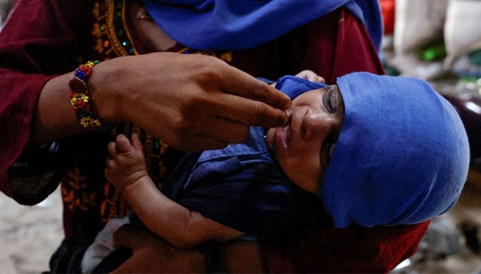 A mother uses her fingers to give water drops to her child during a hot summer day as a heatwave continues, in Jacobabad, Pakistan on May 24, 2024. — Reuters