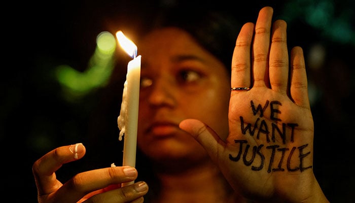 A woman holds a candle during a vigil condemning the rape and murder of a trainee medic at a government-run hospital in Kolkata, on a street in Mumbai, India, August 14, 2024. — Reuters