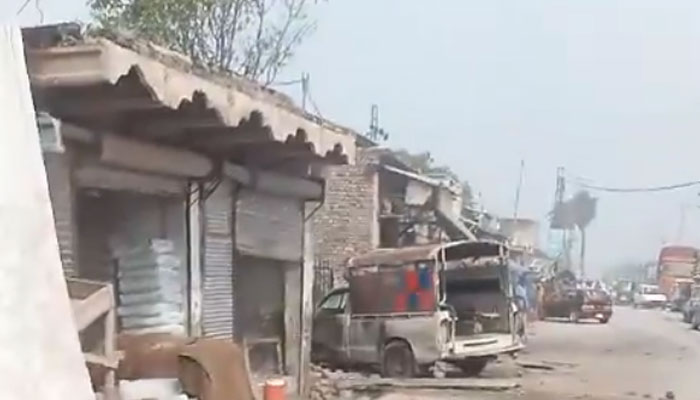 The targeted police vehicle is seen struck by the explosion. — Screengrab via video/Geo News