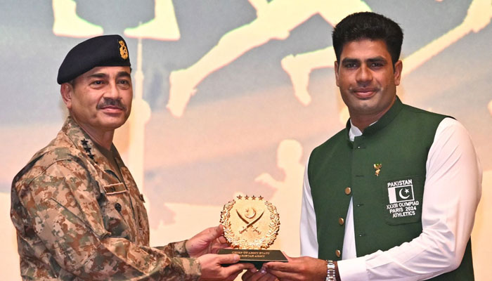 Chief of Army Staff (COAS) General Syed Asim Munir honours Olympian Arshad Nadeem during a ceremony at Army Auditorium GHQ in Rawalpindi on August 16, 2024. — ISPR