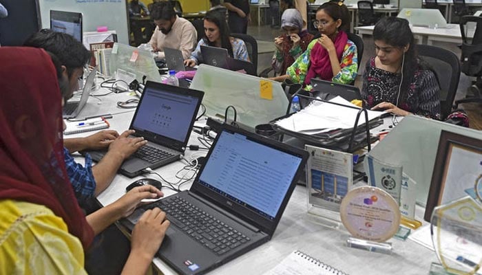 People work at their stations at the National Incubation Centre (NIC) in Lahore.  — AFP/File