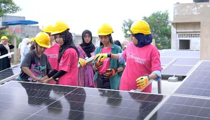 Female engineers take part in installations of solar panels at a location. — Author