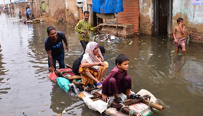 Residents use a raft to move along a waterlogged street in a residential area after a heavy monsoon rainfall in Hyderabad. — AFP/File