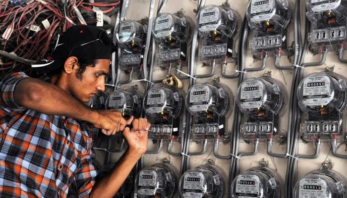 A KE technician fixes a metre at a residential building. — AFP/File