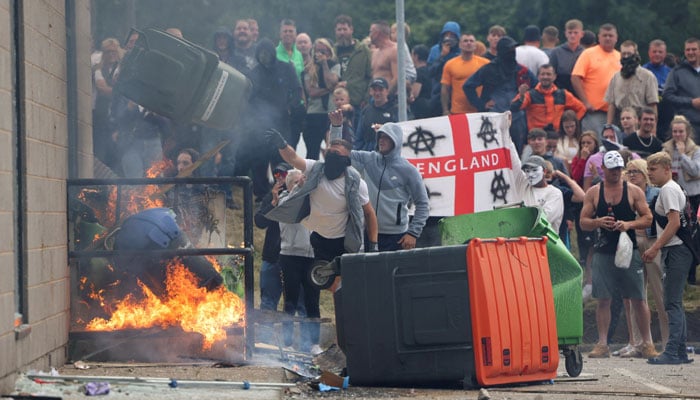 Protesters throw over a trash can during an anti-immigration demonstration in Rotherham, Britain, August 4, 2024. — Reuters