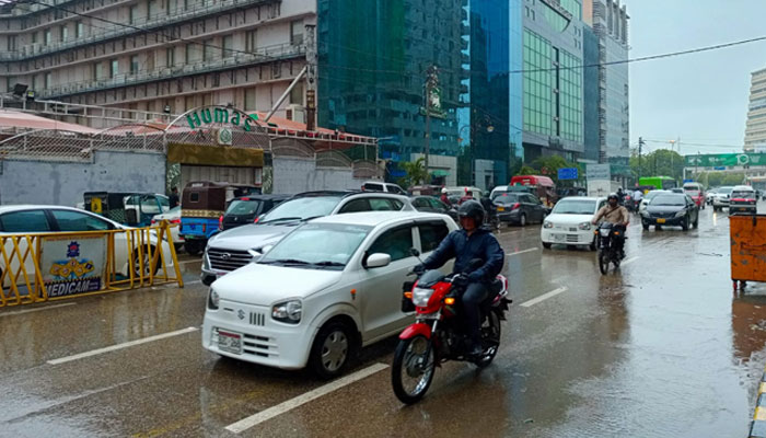 Vehicles pass by at Karachis II Chundrigar Road amid light rain. — Geo.tv/File