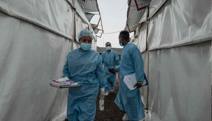 Health workers walk between wards at the Mpox treatment centre at Nyiragongo General Referral Hospital, north of Goma on August 17, 2024. — AFP