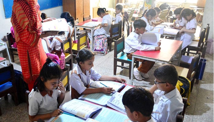 Students laking a lesson at a school in Latifabad, Hyderabad on August 1, 2023. — INP