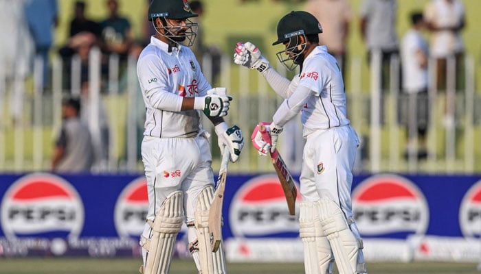 Bangladeshs Litton Das and Mushfiqur Rahim (right) bump their fists during the third day of the first Test cricket match between Pakistan and Bangladesh at the Rawalpindi Cricket Stadium in Rawalpindi on August 23, 2024. — AFP