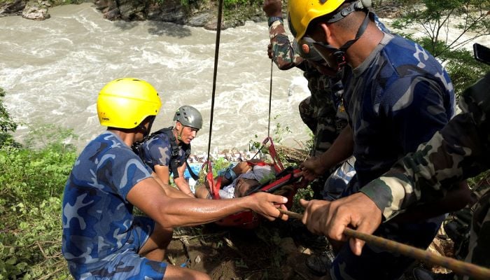 Security force personnel work to rescue injured passengers after a bus carrying Indian passengers traveling to Kathmandu from Pokhara plunged into a river in Tanahun District on August 23, 2024. — Reuters