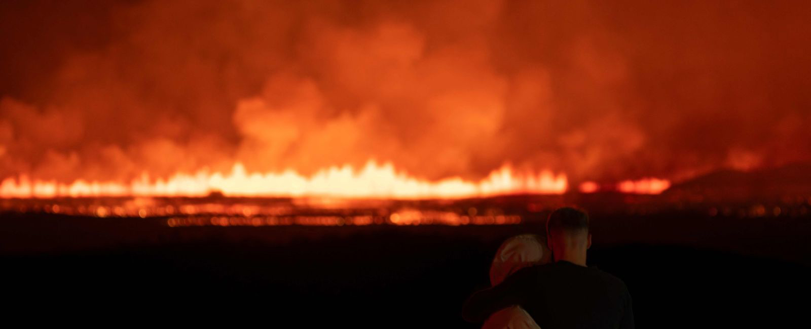 A couple watching lava and smoke erupting from a volcano near Grindavik on the Icelandic peninsula of Reykjanes on August 23, 2024. — AFP