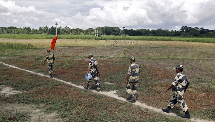 Indian Border Security Force (BSF) soldiers walk across the open border with Bangladesh to attend a flag meeting in West Bengal, India, June 20, 2015. — Reuters