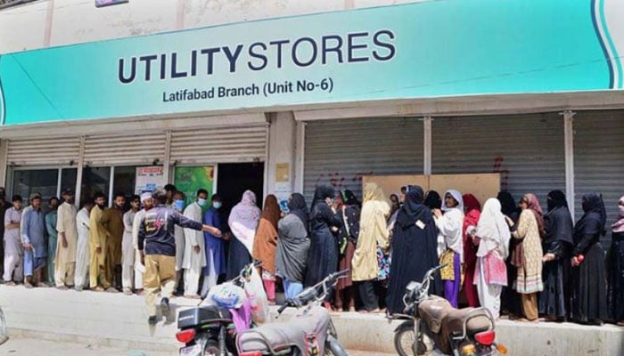 People stand in a queue while waiting for their turn outside a utility store in Hyderabad. — APP/File