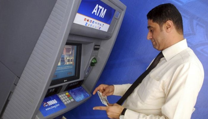 A man uses an ATM for cash withdrawal. — Reuters/File