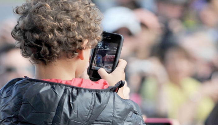 This file photo taken on April 20, 2013 shows a child using a smartphone at Caulfield Racetrack in Melbourne. — AFP