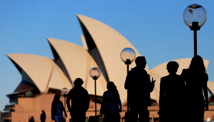 People are silhouetted against the Sydney Opera House at sunset in Australia, November 2, 2016. — Reuters