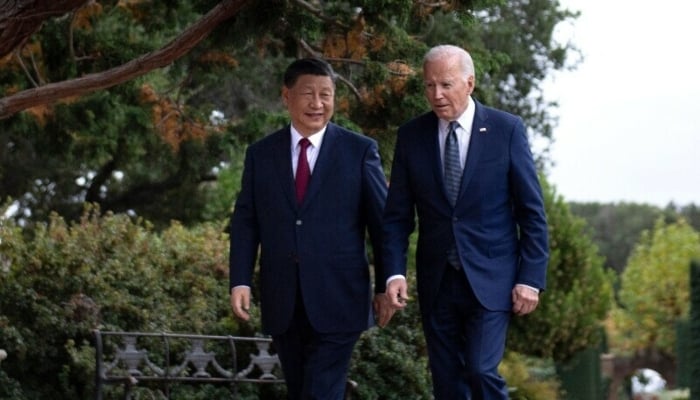 US President Joe Biden (R) and Chinese President Xi Jinping walk together after a meeting in Woodside, California on November 15, 2023. — AFP