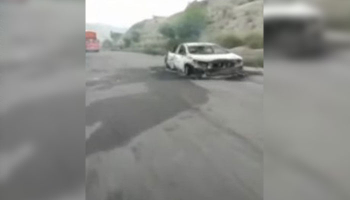 A burnt vehicle can be seen at the site of the incident where armed men offloaded and gunned down around two dozen people in Balochistans Musakhel on August 26, 2024. — Screengrab via Geo News