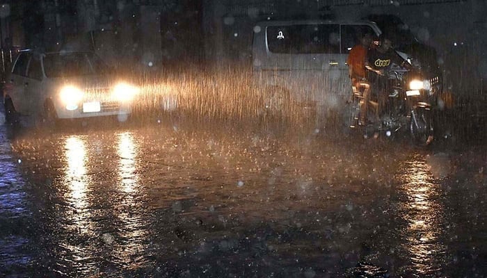 People commute during heavy rain in Karachi. — APP/File