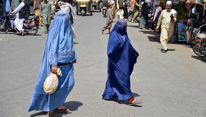 Afghan women walk along a road at a market area in Kandahar. — AFP/File