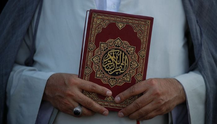 A cleric holding the Holy Quran outside the Swedish embassy in Iraq, Baghdad on June 30, 2023. — AFP