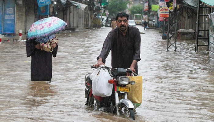 During the heavy rain in Lahore, a person going with own motorcycle from the flood on August 1, 2024. — AFP