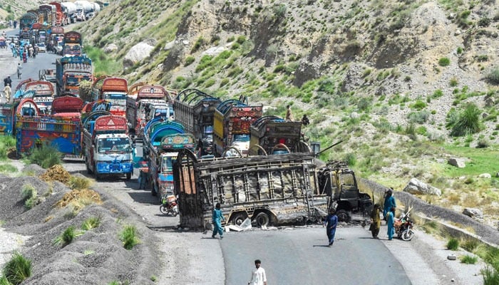 People look at a charred vehicle near a collapsed railway bridge a day after a blast by separatist militants at Kolpur in Bolan district, Balochistan province on August 27, 2024. — AFP