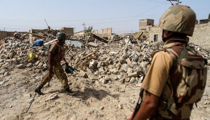 Soldiers stand near debris of a house which was destroyed during a military operation against militants in the town of Miranshah, North Waziristan out July 9, 2014. — Reuters