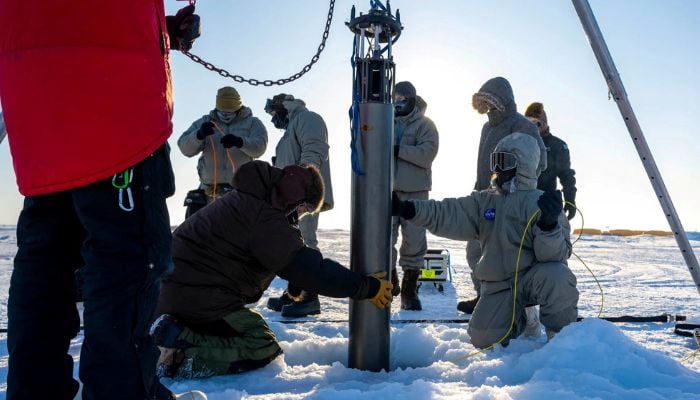 A prototype of a robot built to access underwater areas where Antarctic ice shelves meet land is lowered though the ice during a field test north of Alaska, in March. — Reuters/File