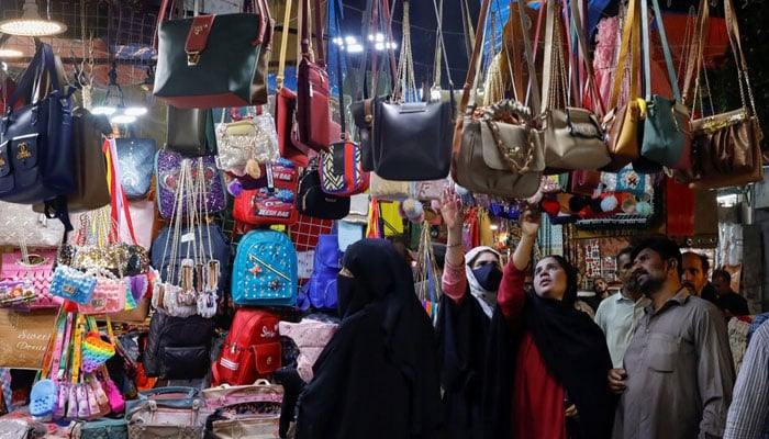 People look at handbags on display outside shops in a market, ahead of Eid al-Fitr celebrations in Karachi, Pakistan April 19, 2023. — Reuters