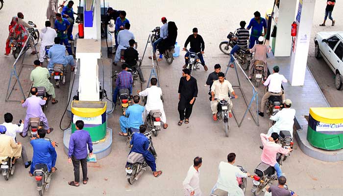 Motorcyclists waiting in a queue to fill fuel tanks of their bikes at a petrol pump in Hyderabad on August 1, 2022. — APP