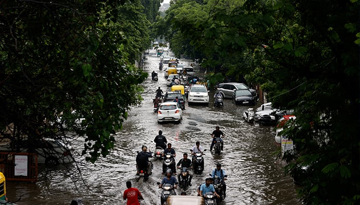 Traffic moves through a flooded road after heavy rains in Ahmedabad, India on August 22, 2024. — Reuters