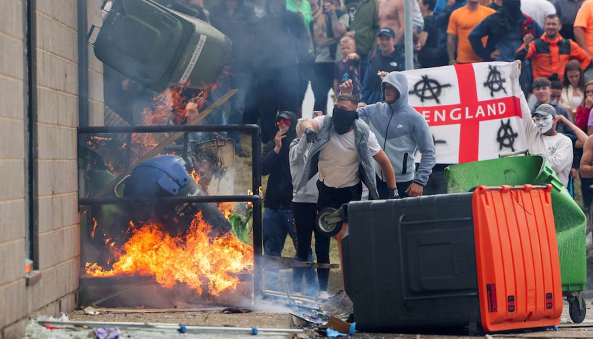 Protestors throw a garbage bin on fire outside a hotel in Rotherham, Britain, August 4, 2024. — Reuters