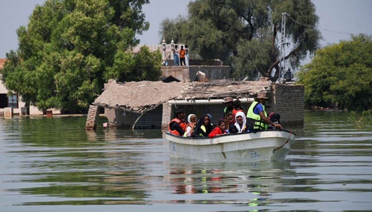 Rescued flood victims sit in a boat, following rains and floods during the monsoon season in village Arazi, in Sehwan, September 11, 2022. — Reuters