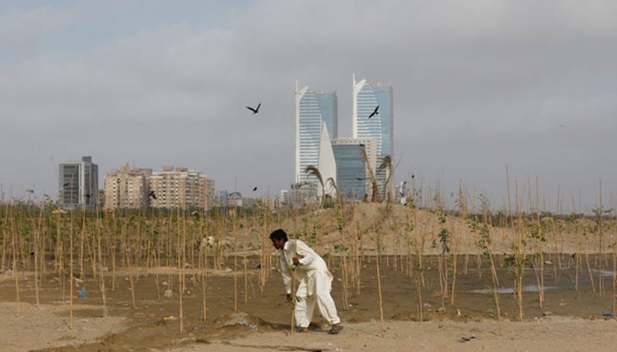 A man plants trees at the Clifton Urban Forest in Karachi, May 26, 2021. — Reuters