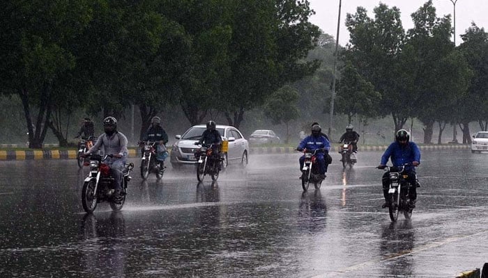 Vehicles and bikers make their way through heavy rain at Zero Point in Islamabad on August 15, 2024. — APP