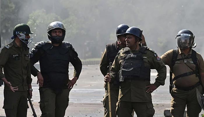 Policeman stand guard as Pakistan Tehreek-e-Insaf party activists and supporters of Imran Khan protest against the arrest of their leader, in Lahore on May 11, 2023. — AFP