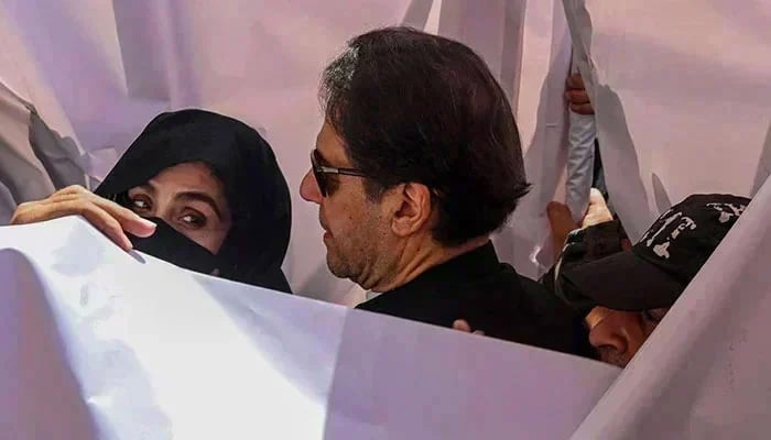 PTI founder Imran Khan with his wife Bushra Bibi arrive to appear in a high court in Lahore on May 15, 2023. — AFP