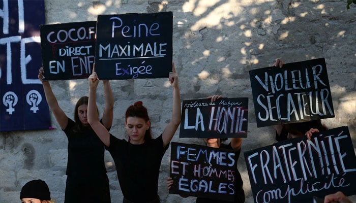 Demonstrators hold placards during a during the trial of a man accused of drugging his wife for nearly ten years and inviting strangers to rape her at their home. — AFP/file