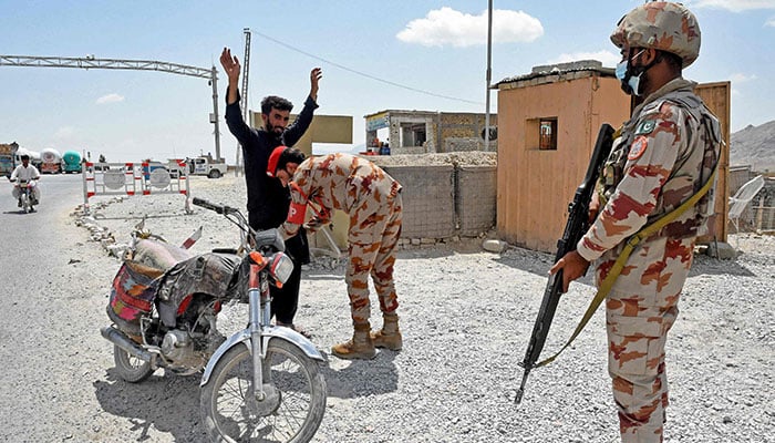 A Pakistani paramilitary ranger frisks a motorcyclist at a checkpoint a day after attacks by militants on the outskirts of Quetta on August 27, 2024. — AFP