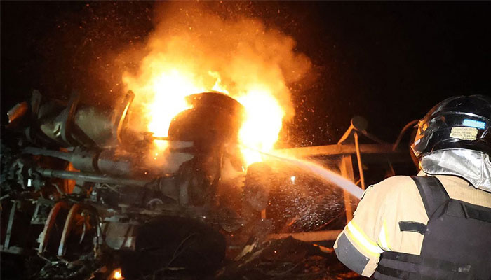 This handout picture taken and released on September 3, 2024 by Ukrainian State Emergency Service press service reportedly shows a fireman trying to extinguish fire on trucks following a missile attack in Dnipro, amid the Russian invasion of Ukraine.— AFP